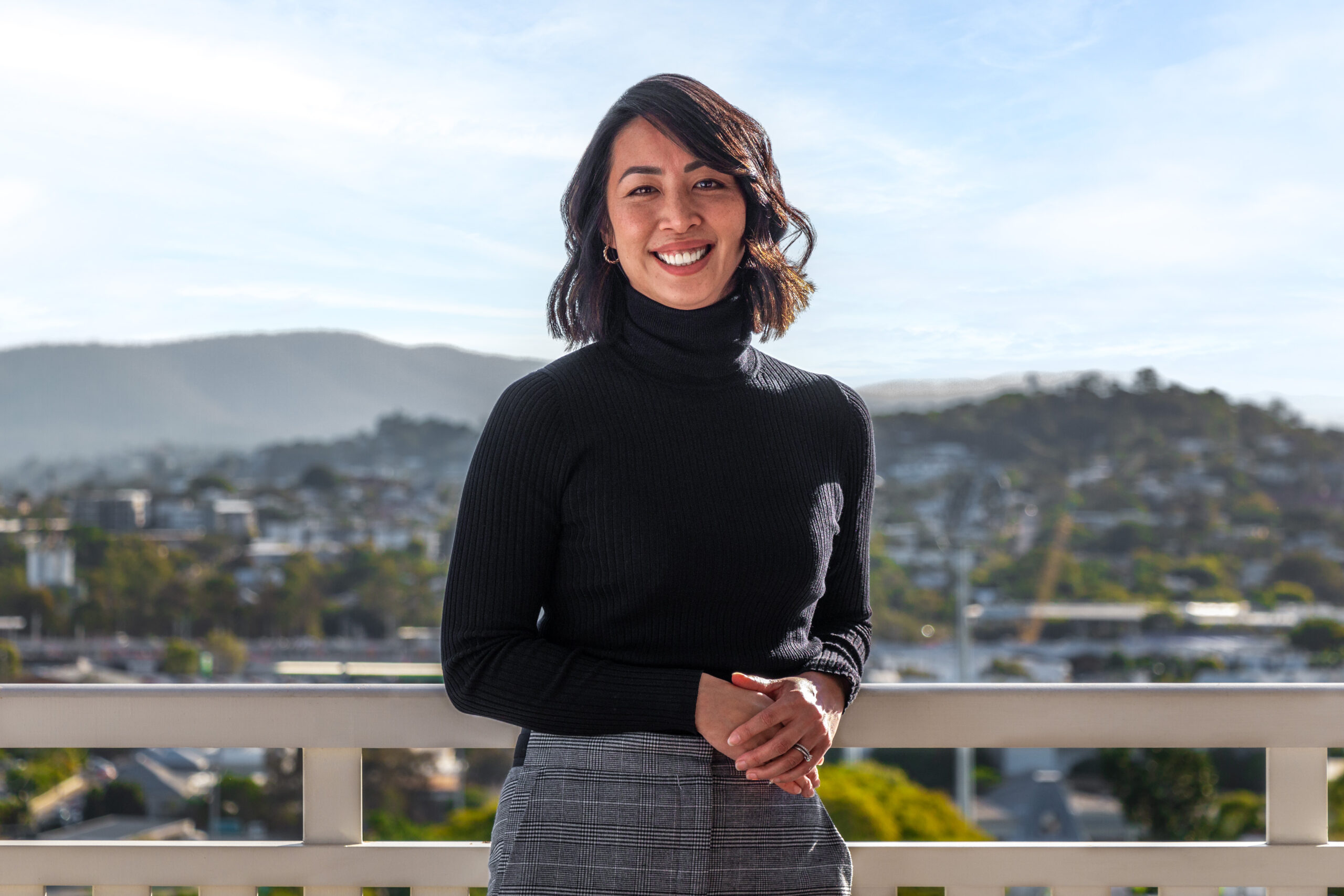 A brunette woman in a black shirt smiling for the camera